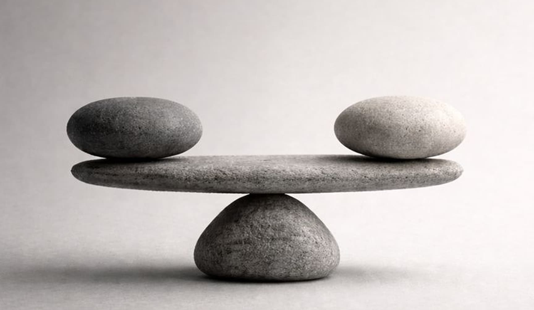Two stones resting in balance on a larger stone