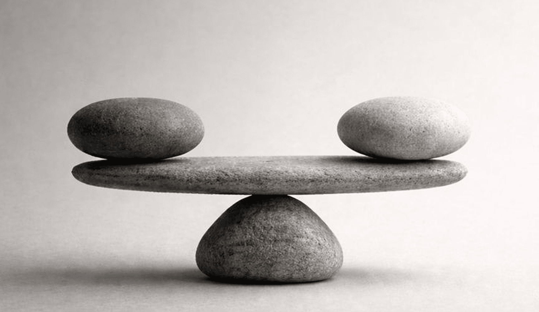 Two stones resting in balance on a larger stone