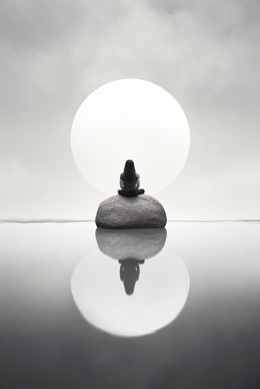 A figure meditating on a stone with a luminous moon behind